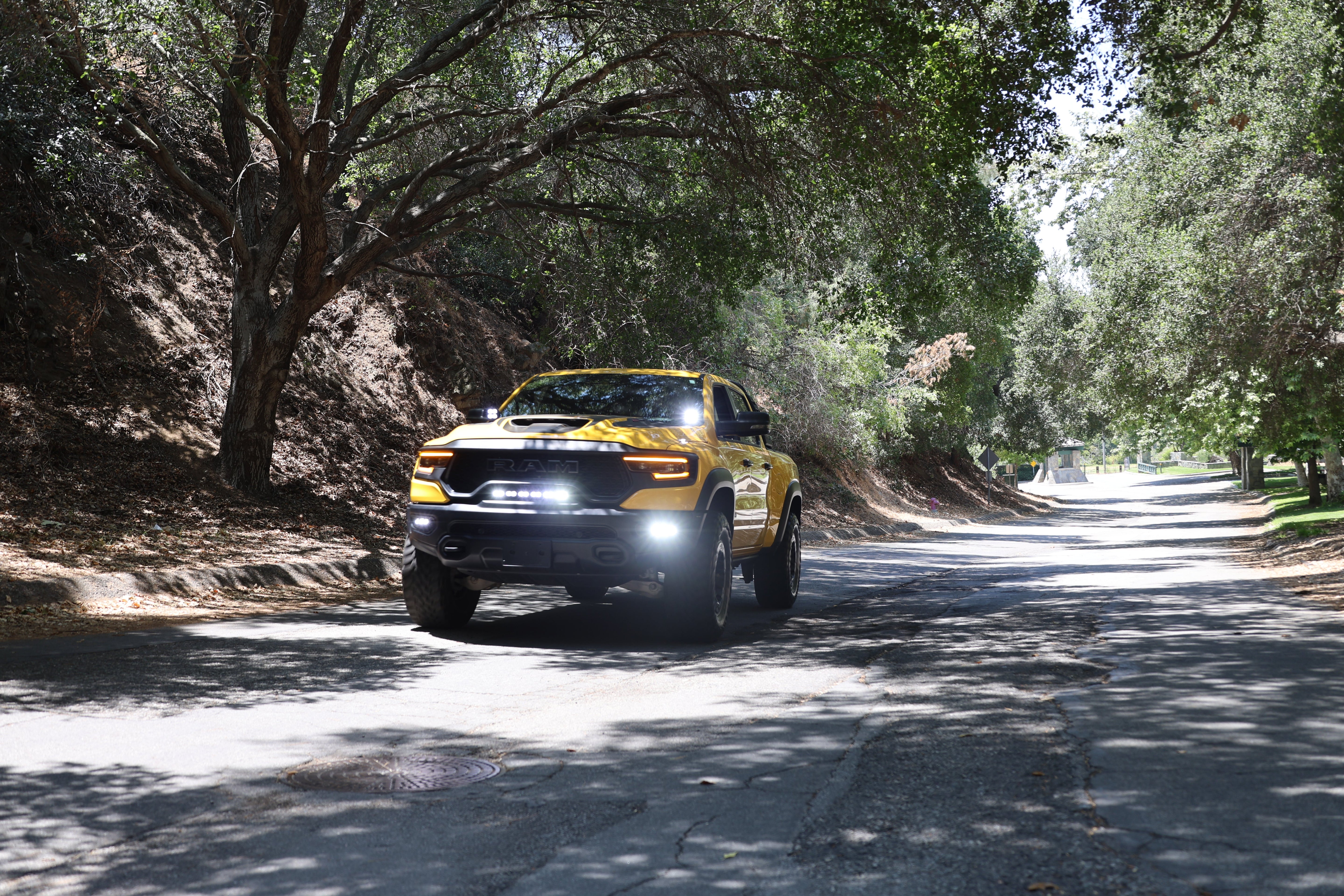 RAM TRX Lightbar 23in PRO installed on yellow RAM 1500 TRX driving on shaded forest road