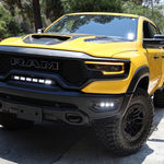 Yellow 2019-2024 RAM 1500 TRX with fog light kit installed, three white LED pods lit in the front bumper, front three-quarter view