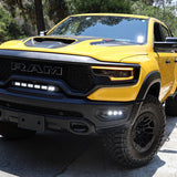 Yellow 2019-2024 RAM 1500 TRX with fog light kit installed, three white LED pods lit in the front bumper, front three-quarter view