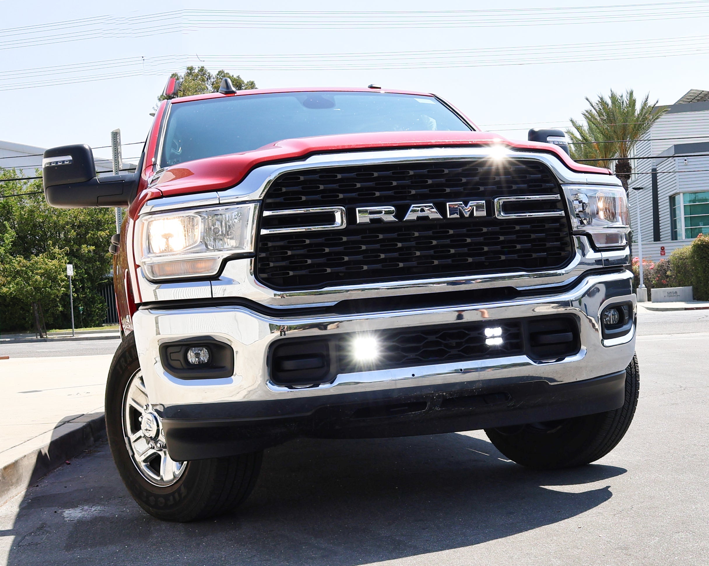 Alt Tag: RAM 2500 lightbar Bumper Light kit installed on 2019-2024 RAM 2500 HD with bright lower grille LED light pods on city street
