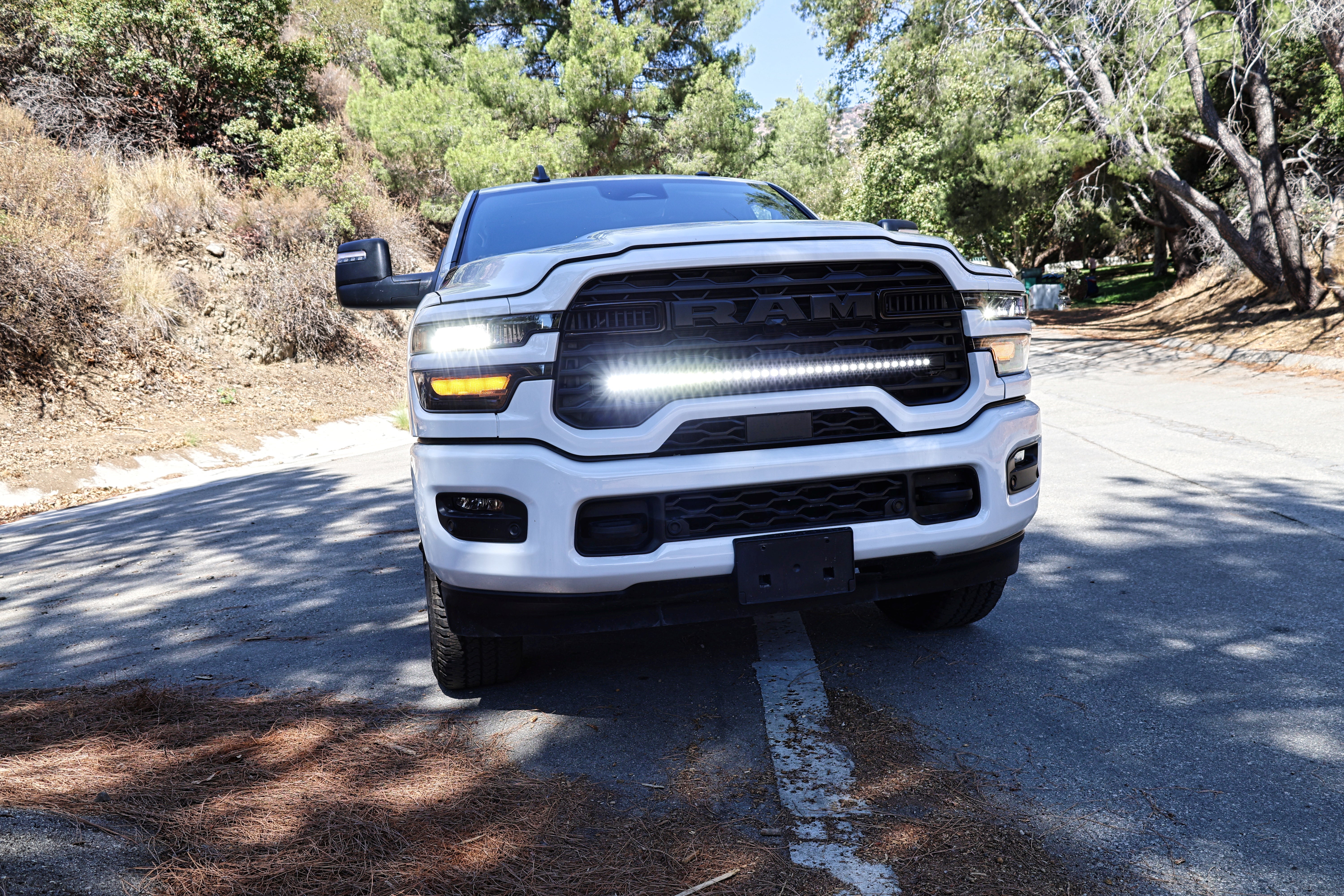 white 2025 ram with light bar front grille for off roading