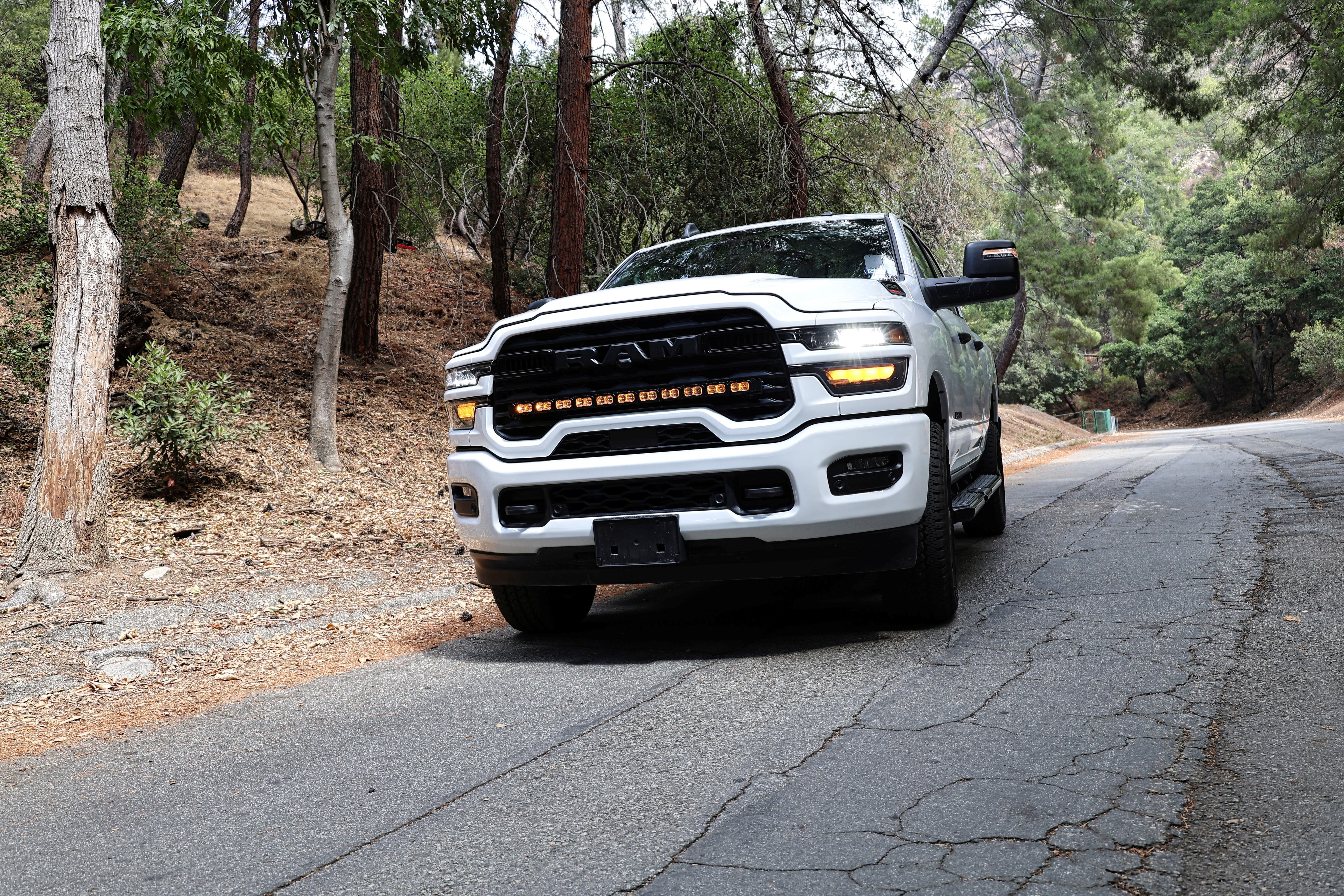 2025+ RAM 2500 light bar PRO 40in curved LED grille mount on white RAM 2500 driving on forest road