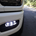 RAM 2500 Fog Light Kit installed on white RAM 2500 truck front bumper with LED fog lights illuminated on street