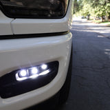 RAM 2500 Fog Light Kit installed on white RAM 2500 truck front bumper with LED fog lights illuminated on street