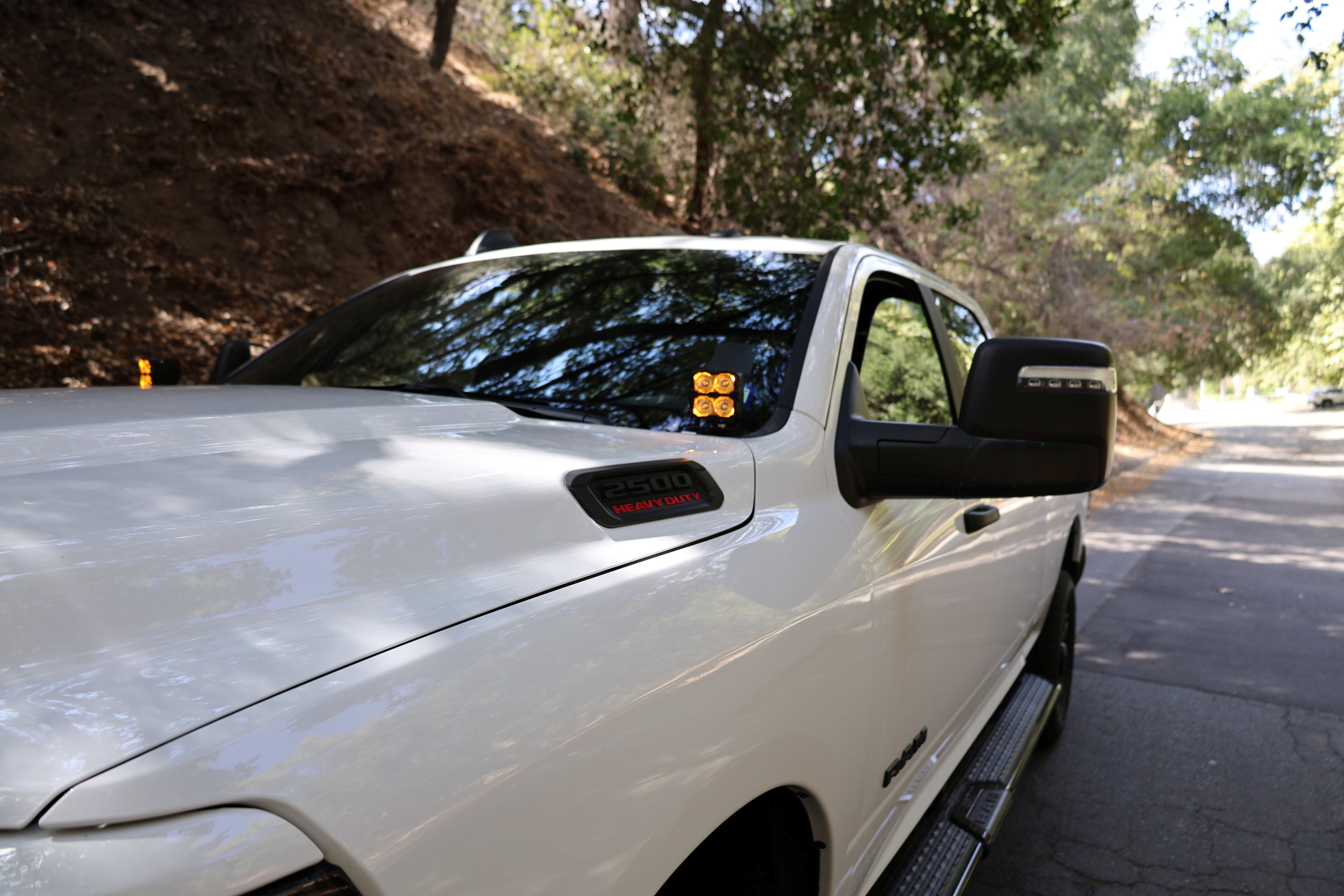 RAM 2500 Ditch Lights PRO dual color white LED with amber DRL backglow installed on 2019-24 RAM 2500 truck hood