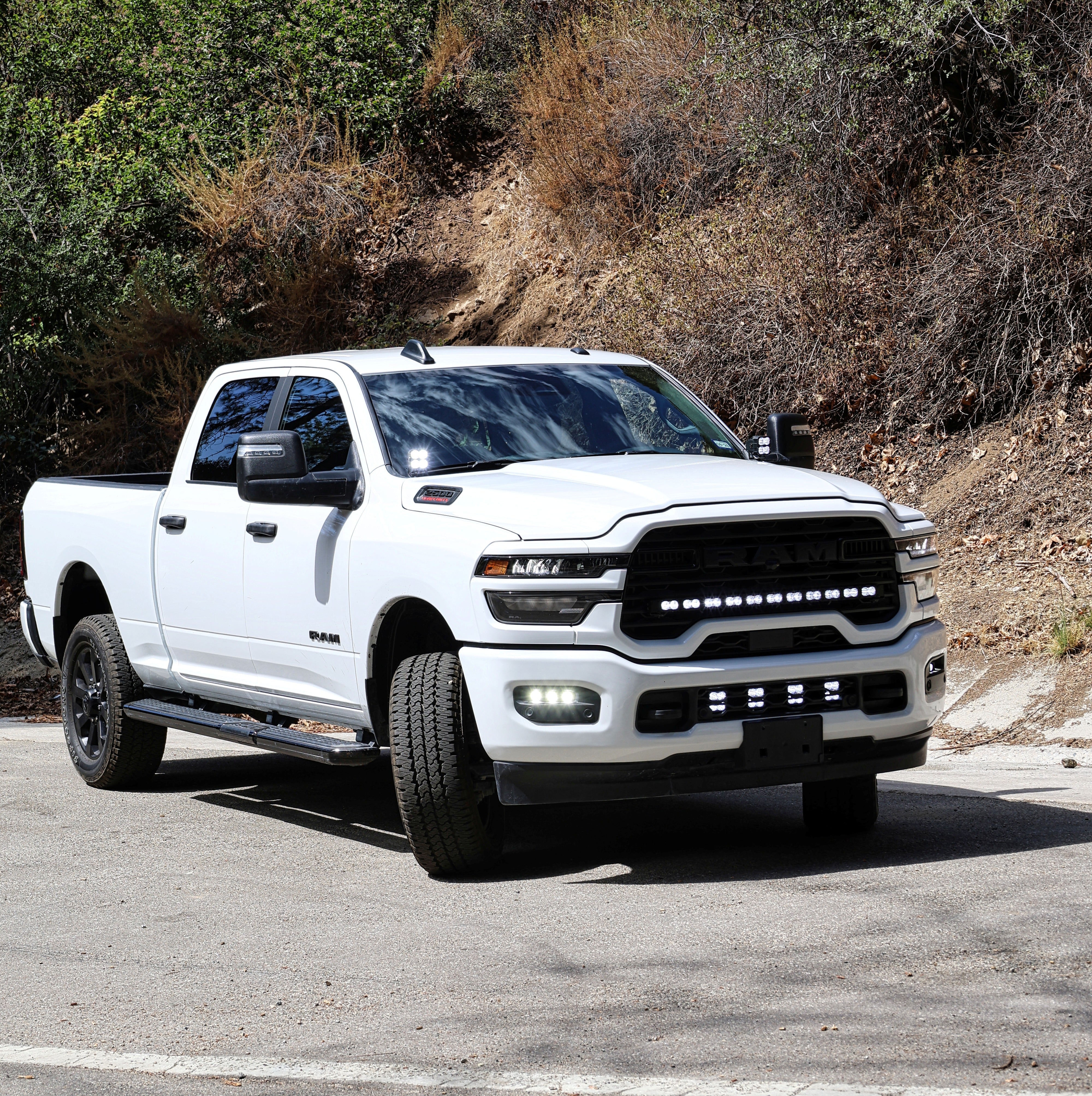 RAM 2500 Fog Light Kit installed on white RAM 2500 truck, bright LED fog lights illuminated on front bumper