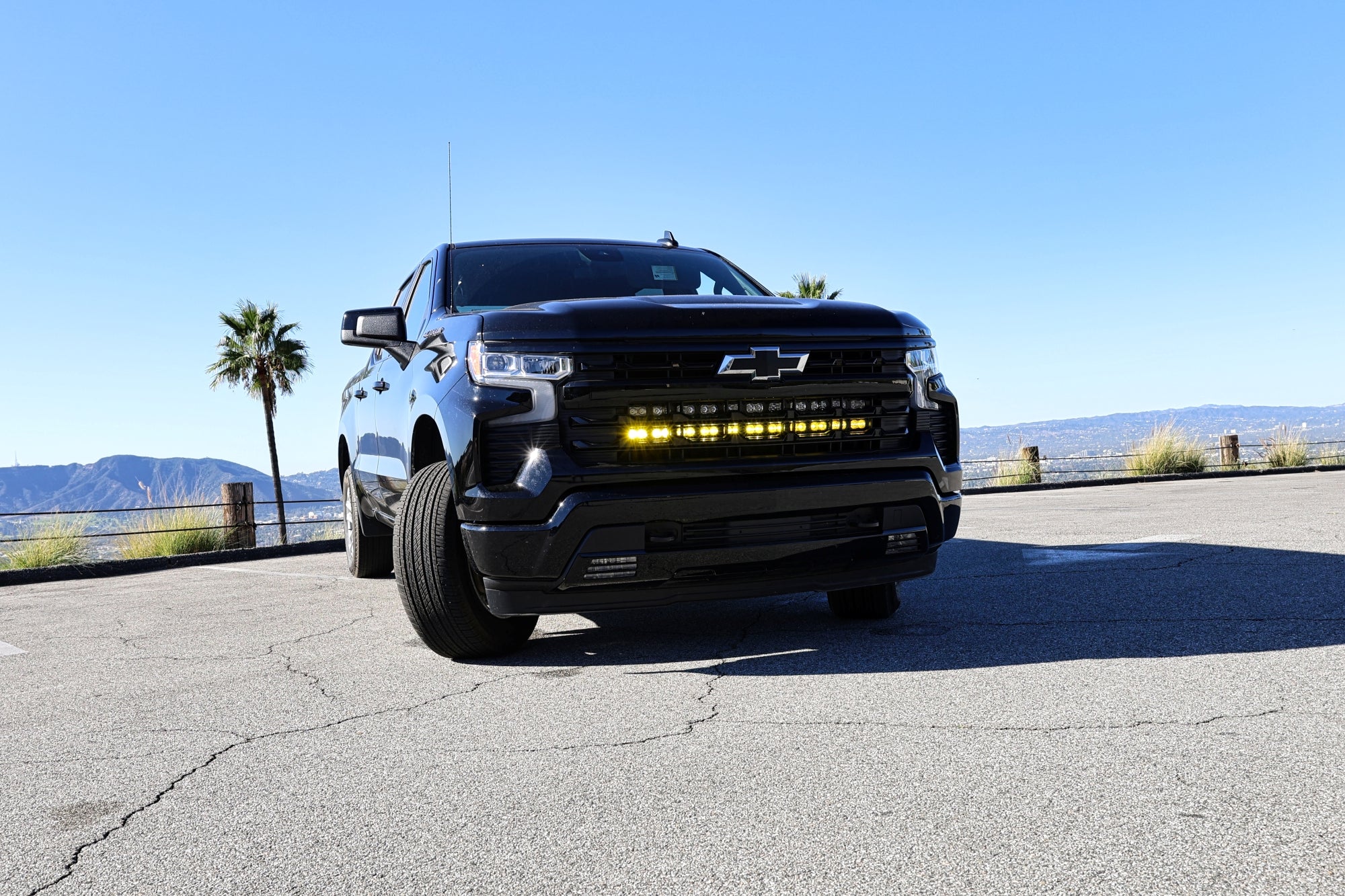 black chevrolet silverado 1500 with led off road light bars behind the grille