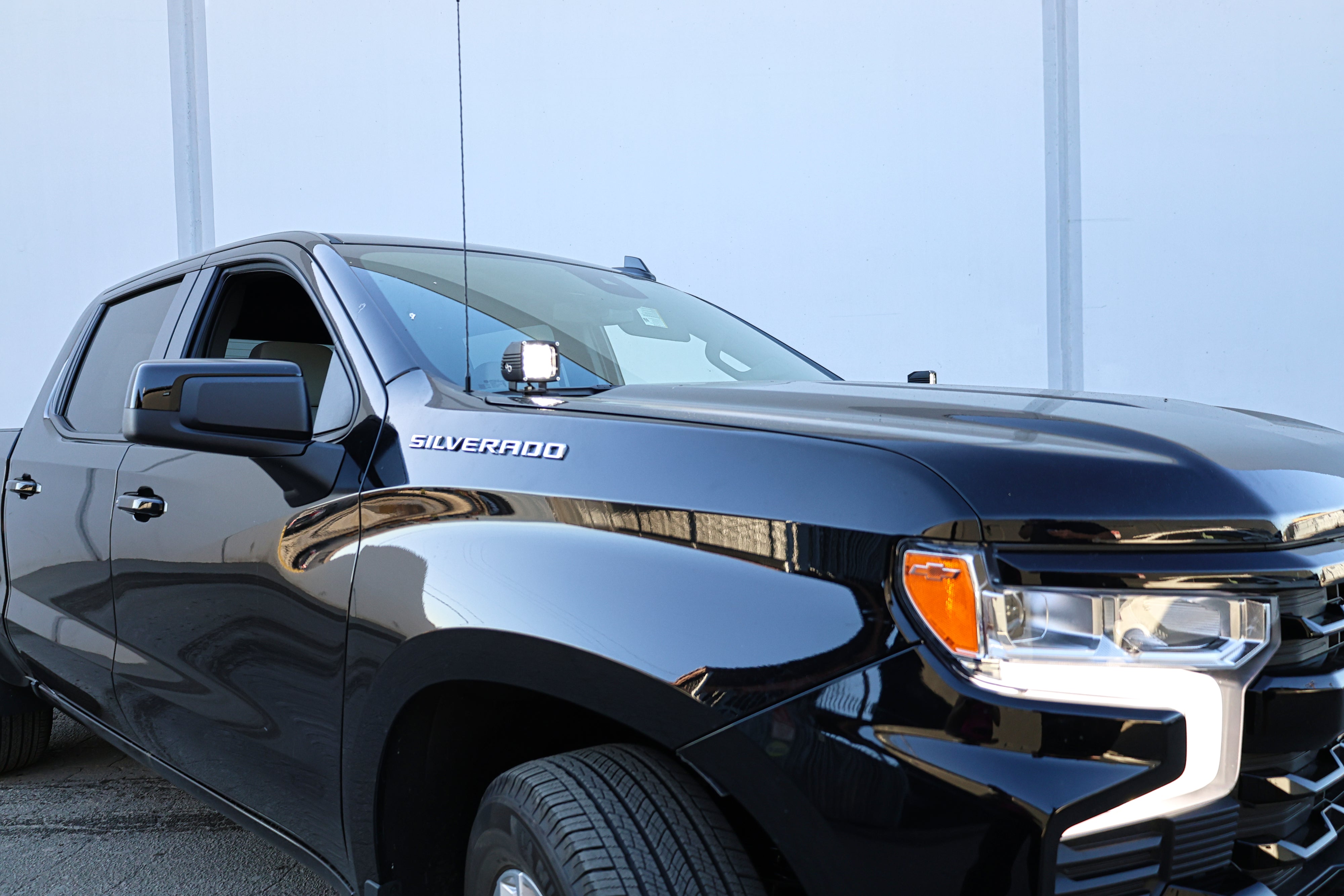 Silverado 1500 ditch lights installed on black 2022 Chevrolet Silverado 1500 front fender, close-up of dual color LED pods