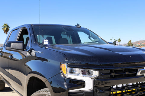 2023 black chevrolet silverado 1500 with led off road light bars behind the grille and hood mounts