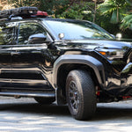 2025 Toyota 4Runner with roof rack equipped with 4Runner Light Bars 11in slim LED front bumper lights on forest road