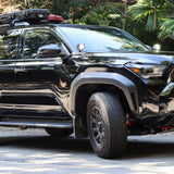 2025 Toyota 4Runner with roof rack equipped with 4Runner Light Bars 11in slim LED front bumper lights on forest road