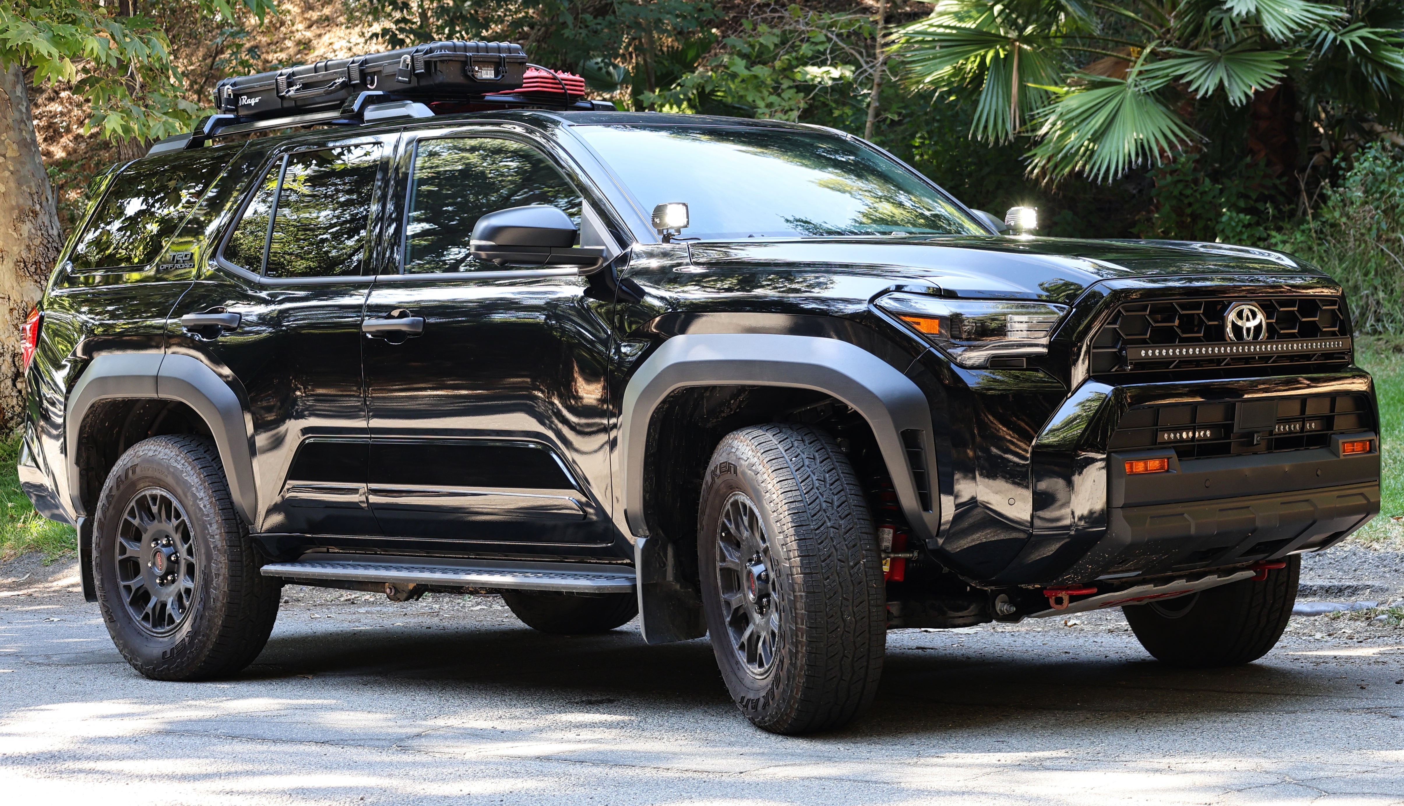 2025 Toyota 4Runner with roof rack equipped with 4Runner Light Bars 11in slim LED front bumper lights on forest road