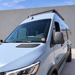 2019+ Mercedes Sprinter van with a ditch light glowing amber at the mirror base, three-quarter view