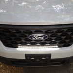 ford maverick light bar mounted behind grille on 2025 ford maverick front bumper, slim curved LED light bar illuminated