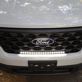 ford maverick light bar mounted behind grille on 2025 ford maverick front bumper, slim curved LED light bar illuminated