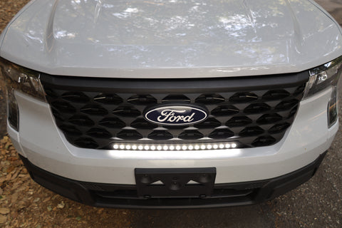 ford maverick light bar mounted behind grille on 2025 ford maverick front bumper, slim curved LED light bar illuminated