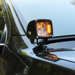 2024 Ford Ranger Raptor hood mount LED lights with amber backglow installed on a black vehicle.