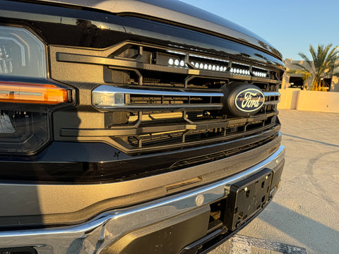 close up view 2024 ford f150 with white led light bar behind the grille 