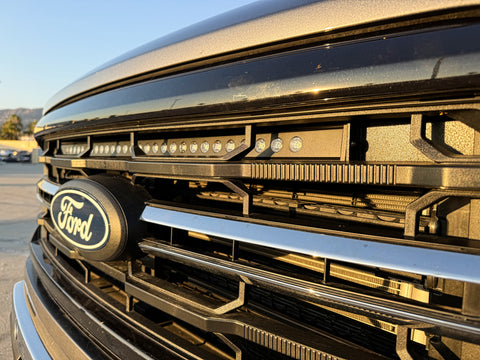 close up view 2024 ford f150 with led light bar behind the grille