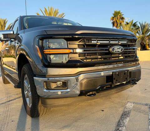 gray 2024 ford f150 with white led light bar behind the grille 