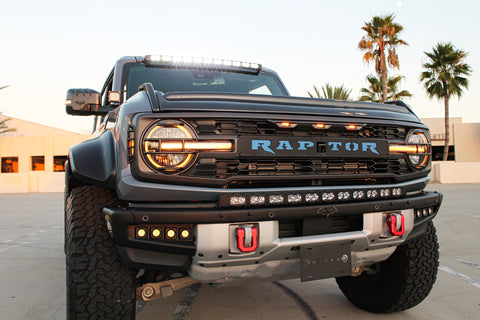 grey ford bronco raptor with white led light bar on top of windshield and curved led light bar on top of bumper with fog lights