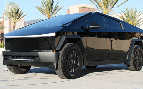 black tesla cybertruck with white curved LED light bar in the bumper