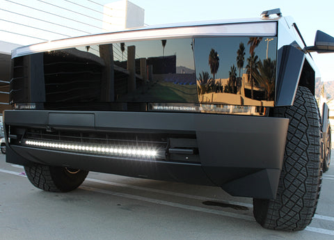 black tesla cybertruck with white curved LED light bar in the bumper