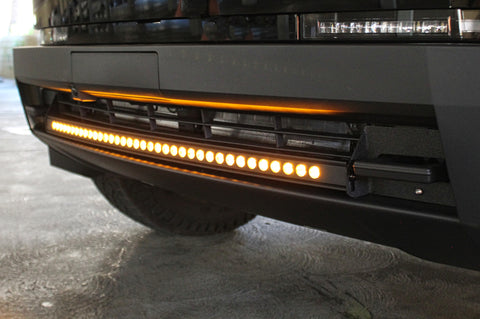 close up view black tesla cybertruck with amber curved LED light bar in the bumper