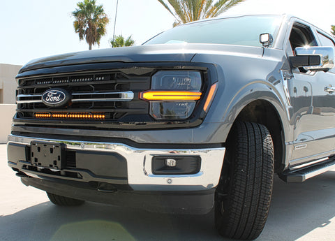 grey 2024 ford f150 with amber led light bar behind the grille 