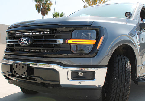 grey 2024 ford f150 hood mount ditch lights and white led light bar behind the grille 