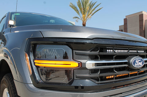 grey 2024 ford f150 with 2 led light bars behind the grille white and amber, and white led ditch lights