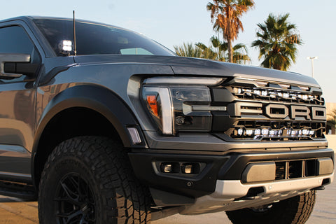 gray 2024 ford raptor gen 3 with 2 light bars white behind the grille and ditch lights for off roading