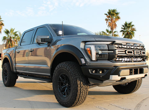 gray 2024 ford raptor gen 3 with 2 light bars white behind the grille and ditch lights for off roading