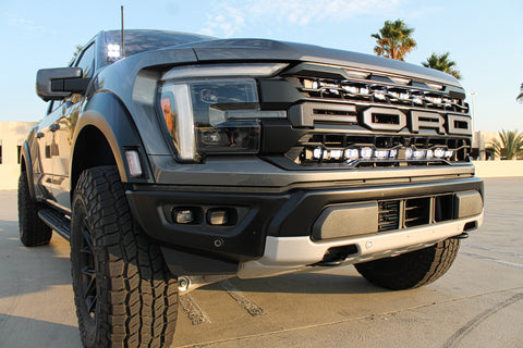 gray 2024 ford raptor gen 3 with 2 light bars white behind the grille and ditch lights for off roading