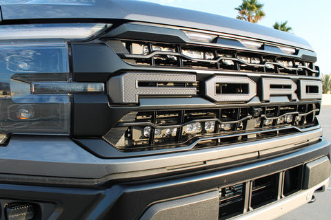 gray 2024 ford raptor gen 3 with 2 light bars behind the grille for off roading