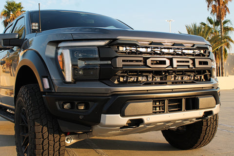 gray 2024 ford raptor gen 3 with white light bar behind the grille and ditch lights for off roading