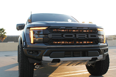 gray 2024 ford raptor gen 3 with 2 light bars color amber backglow behind the grille and ditch lights for off roading