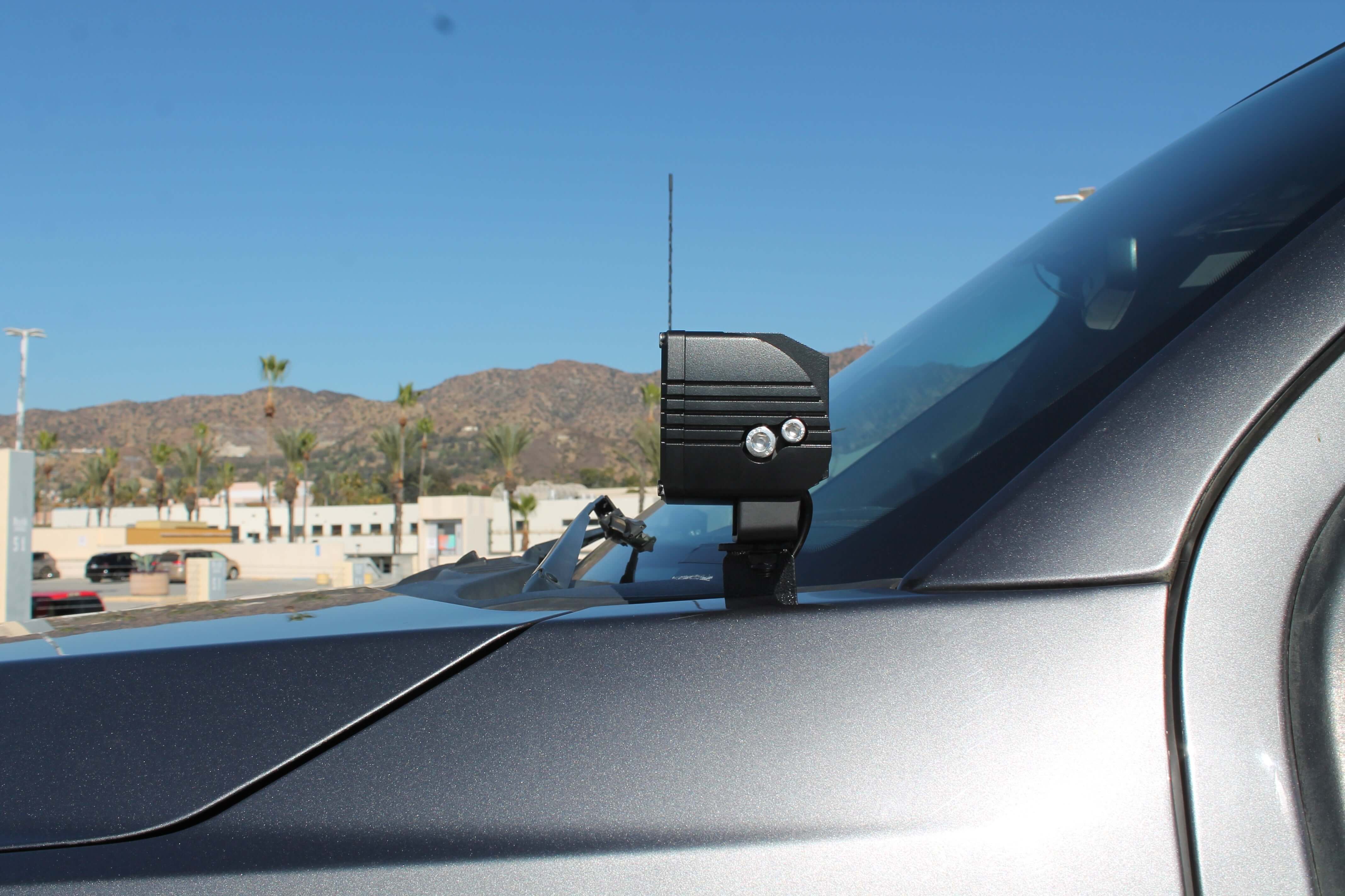Ford Super Duty ditch lights mounted on a 2020-2022 F-Series truck, side view of the dash area with a rugged black lighting fixture and vehicle windshield