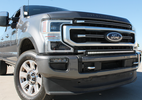 gray 2021 ford super duty with white ditch lights and white light bar on top of bumper