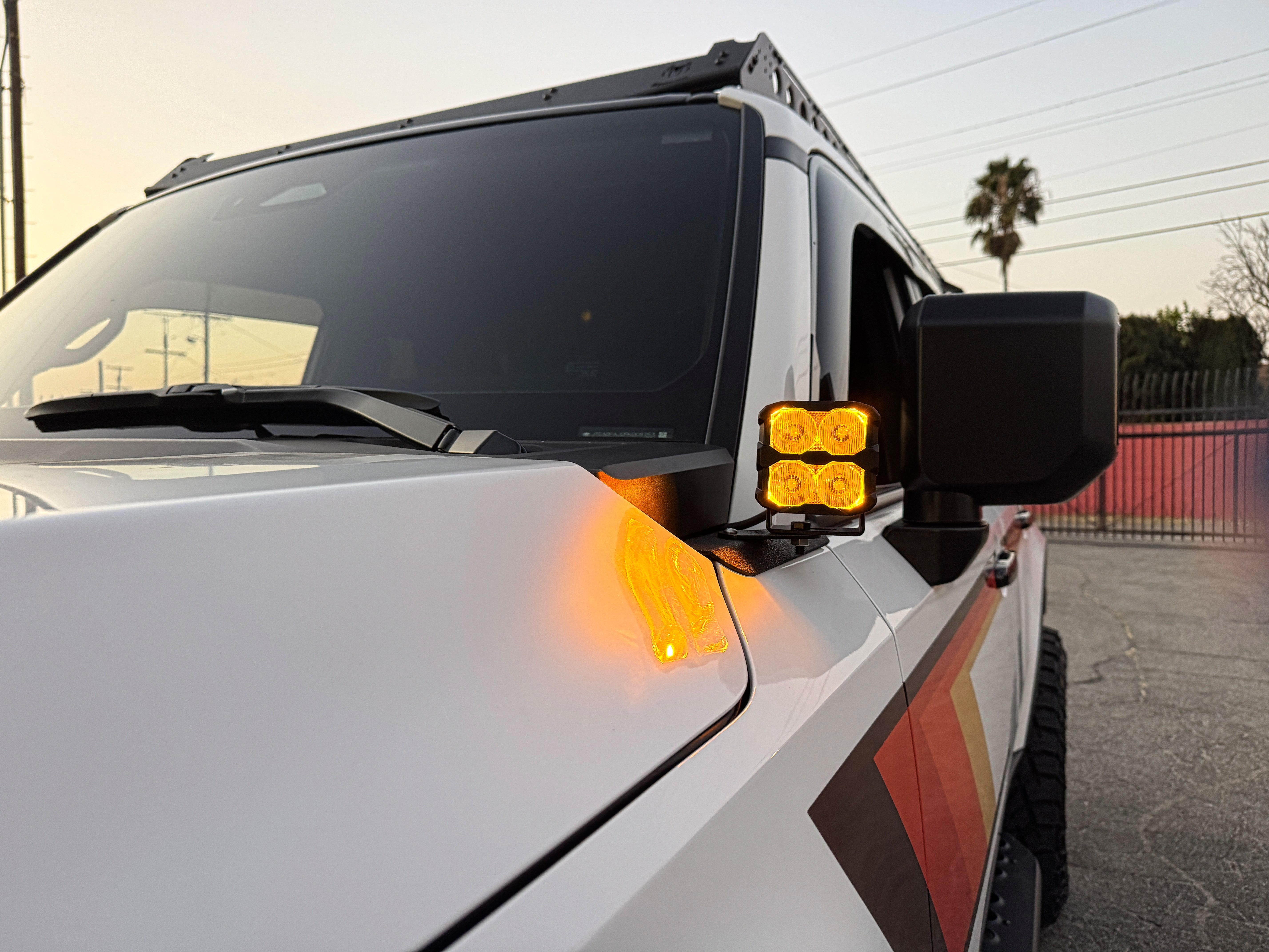 Land Cruiser ditch lights PRO for 2024+ on white Toyota Land Cruiser with amber DRL backglow and dual-color LEDs