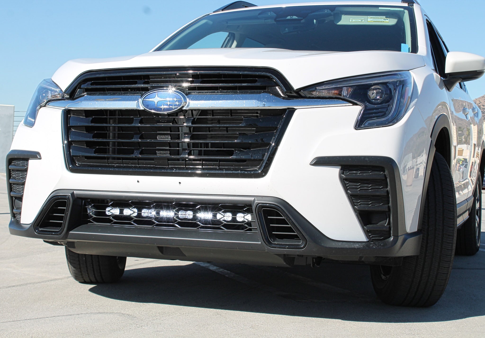 white 2024 subaru ascent with led light bar behind grille