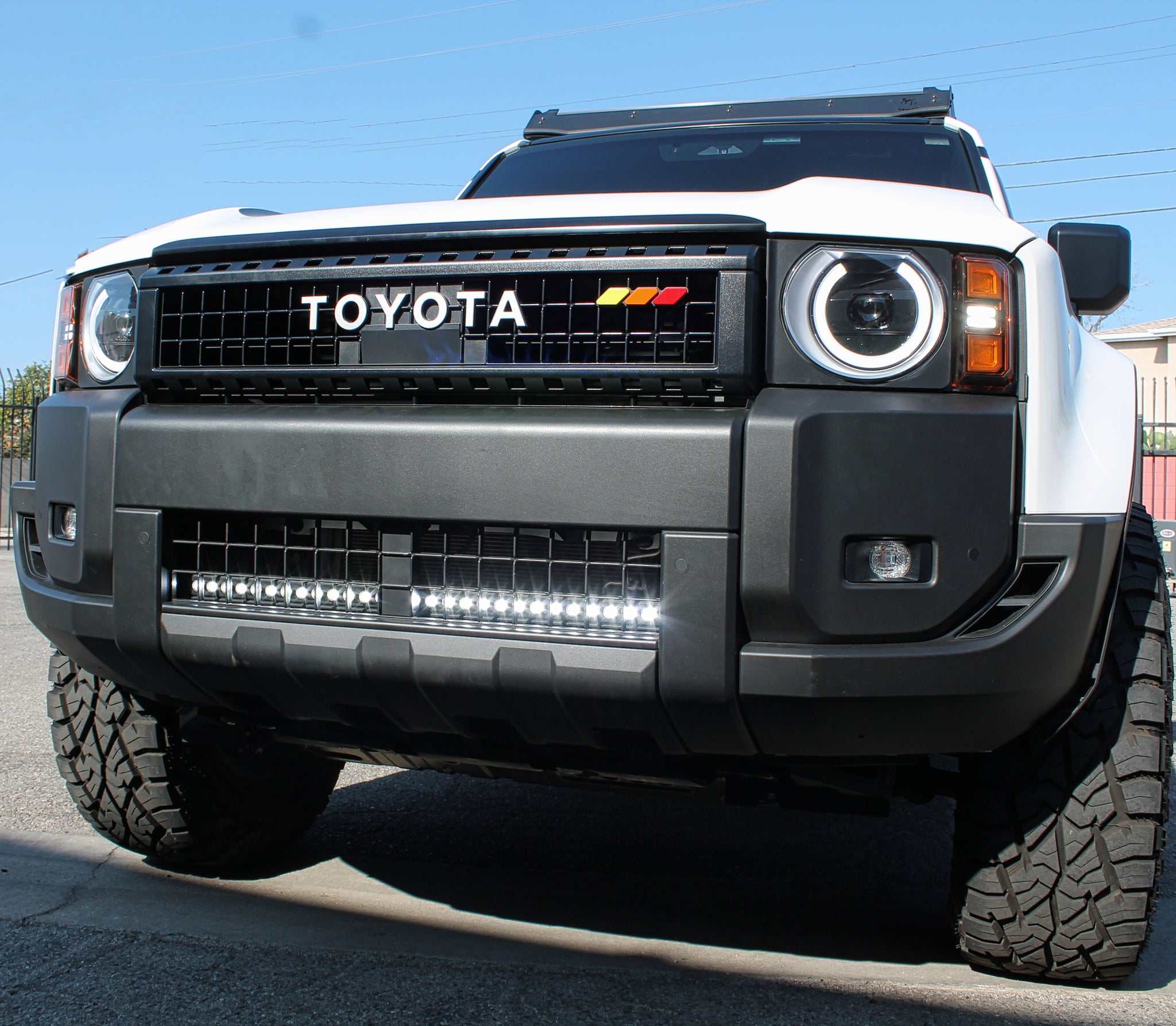 white 2024 toyota land cruise with 1 white led light bar bar hind the grille for off roading