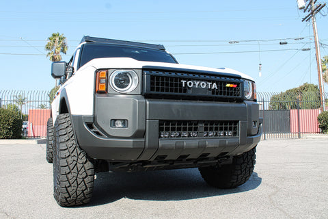 white toyota land cruiser with light bar behind the grille for off roading