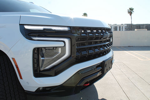 white 2025 chevrolet tahoe with light bar behind the grille for off roading, chevy suburban lights