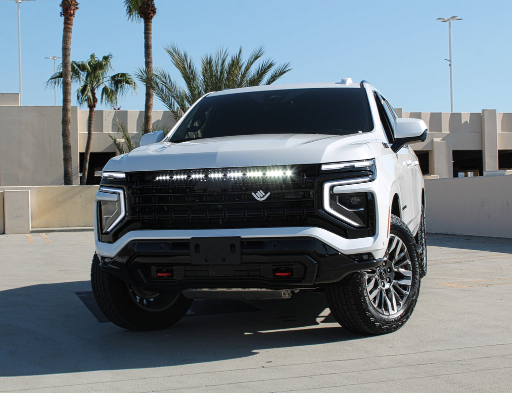 white 2025 chevrolet tahoe with light bar behind the grille for off roading