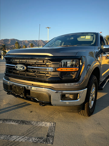 gray 2024 ford f150 with led light bar behind the grille 