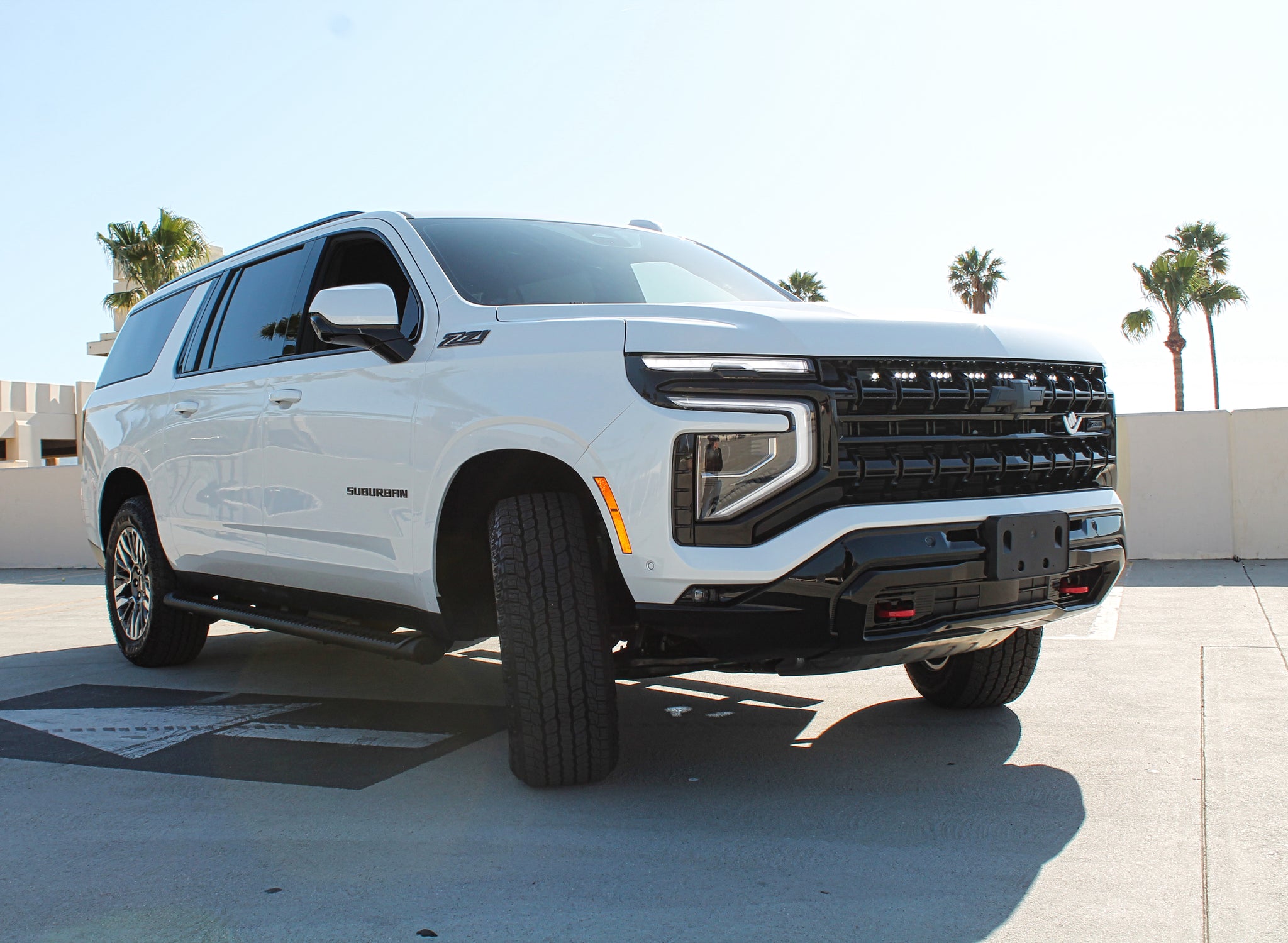 white 2025 chevrolet tahoe with light bar behind the grille for off roading