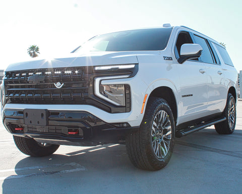 white 2025 chevrolet tahoe with light bar behind the grille for off roading