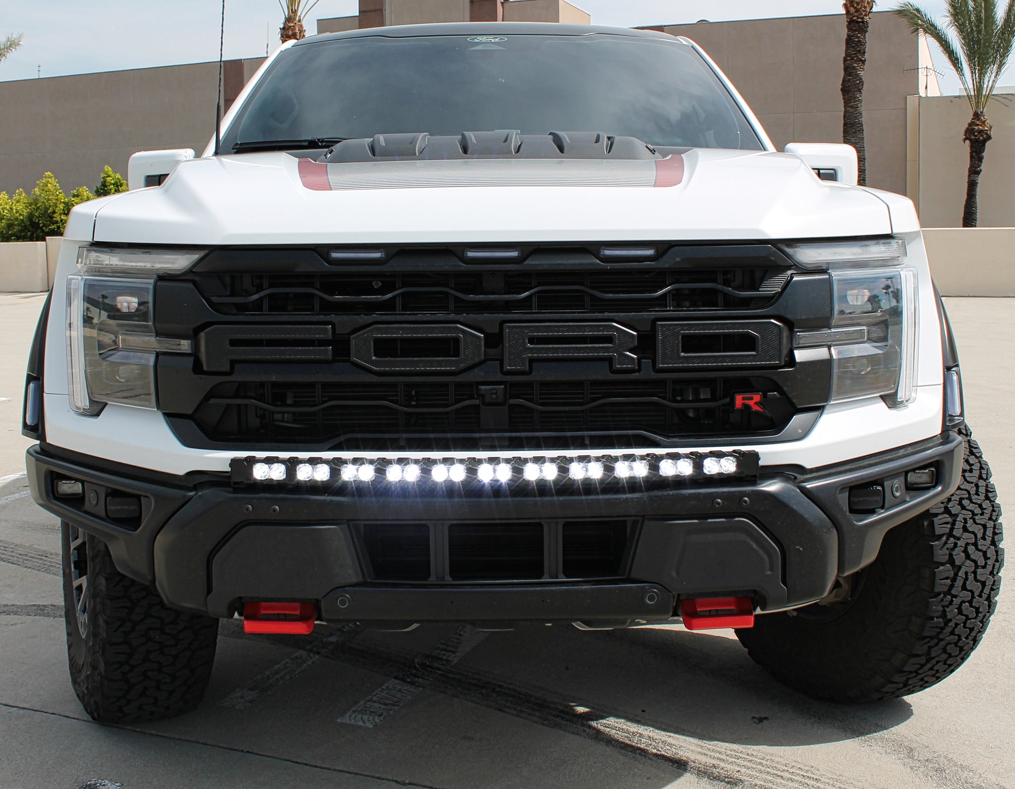 white ford raptor r with a light bar for off roading on top of modular bumper