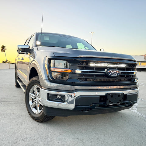 gray 2024 ford f150 with white led light bar behind the grille 